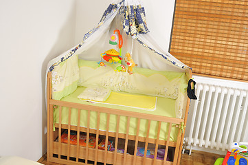 Image showing baby bed with colorful toys indoor