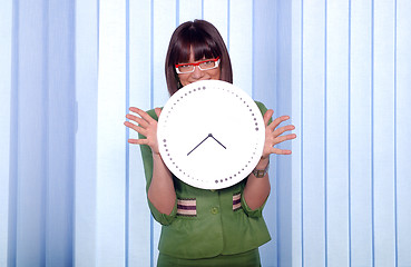 Image showing .a pretty business woman hiding behind a clock