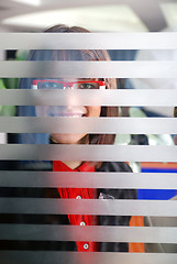 Image showing young businesswoman looking trought transparent wall