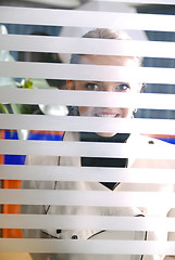 Image showing young businesswoman looking trought transparent wall