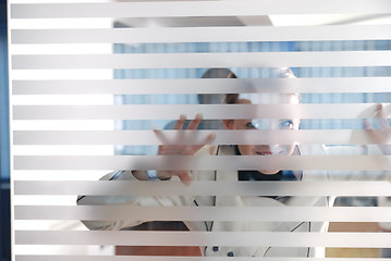Image showing young businesswoman looking trought transparent wall