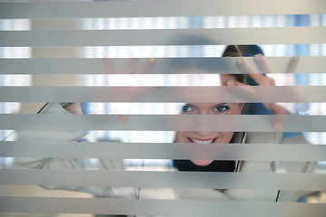 Image showing young businesswoman looking trought transparent wall