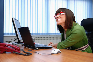 Image showing Smiling young businesswoman working on a laptop in the office.