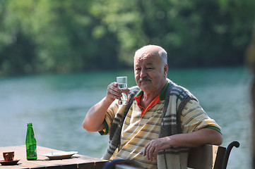 Image showing senior man eat desser at outdoor restaurant