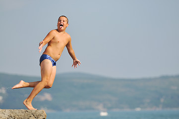 Image showing boy jump sea