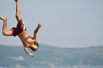 Image showing boy jump sea