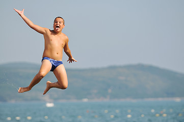 Image showing boy jump sea