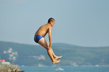 Image showing boy jump sea