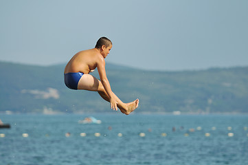 Image showing boy jump sea