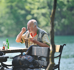 Image showing senior man eat desser at outdoor restaurant