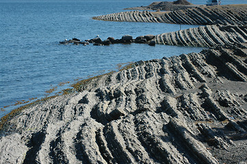 Image showing Jagged rock meets water