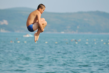 Image showing boy jump sea