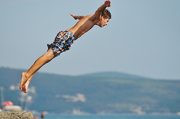 Image showing boy jump sea