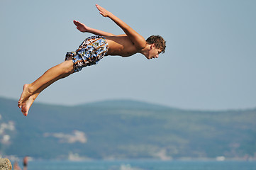 Image showing boy jump sea