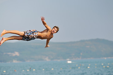 Image showing boy jump sea