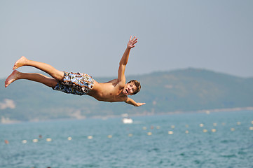 Image showing boy jump sea