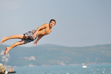 Image showing boy jump sea