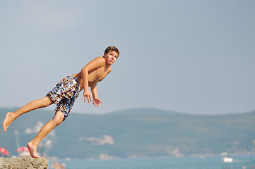 Image showing boy jump sea