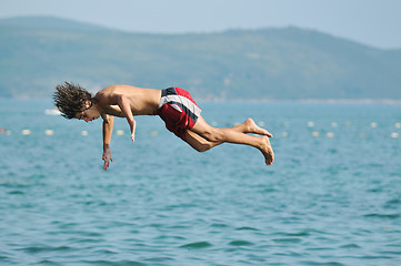 Image showing boy jump sea