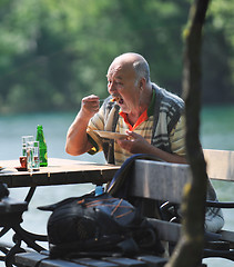 Image showing senior man eat desser at outdoor restaurant