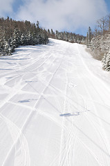 Image showing tracks on ski slopes at beautiful sunny  winter day