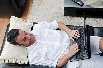 Image showing Portrait of a relaxed young guy using laptop at home