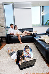 Image showing happy young family have fun and working on laptop at home