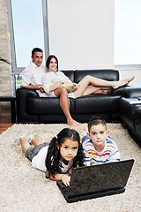 Image showing happy young family have fun and working on laptop at home