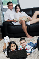 Image showing happy young family have fun and working on laptop at home