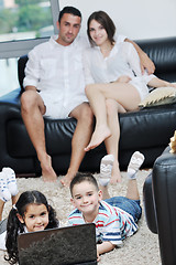 Image showing happy young family have fun and working on laptop at home