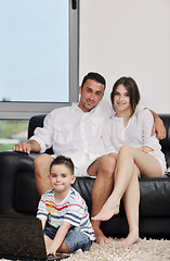 Image showing happy young family have fun and working on laptop at home