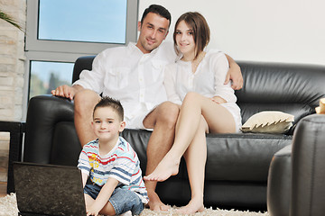 Image showing happy young family have fun and working on laptop at home