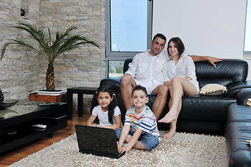 Image showing happy young family have fun and working on laptop at home