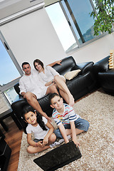 Image showing happy young family have fun and working on laptop at home