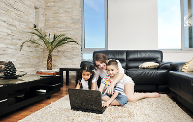 Image showing happy young family have fun and working on laptop at home