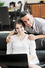 Image showing happy young family have fun and working on laptop at home