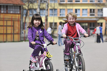 Image showing happy childrens group learning to drive bicycle