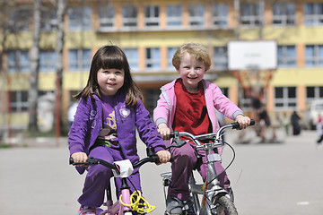 Image showing happy childrens group learning to drive bicycle