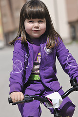 Image showing cute little girl driving bicyle at sunny day