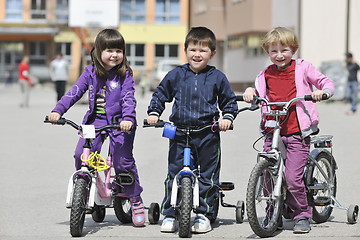 Image showing happy childrens group learning to drive bicycle