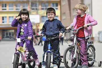 Image showing happy childrens group learning to drive bicycle