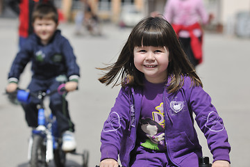 Image showing happy childrens group learning to drive bicycle