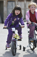 Image showing happy childrens group learning to drive bicycle