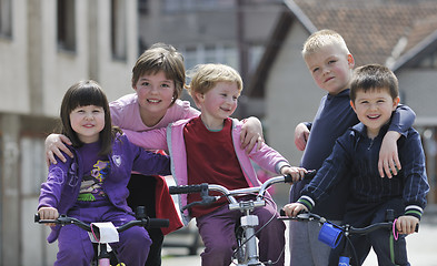 Image showing happy childrens group learning to drive bicycle