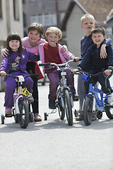 Image showing happy childrens group learning to drive bicycle