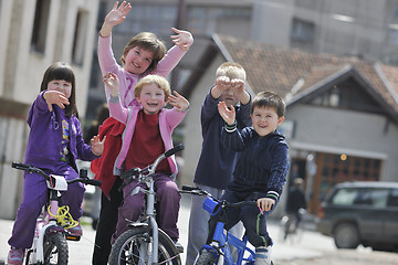 Image showing happy childrens group learning to drive bicycle