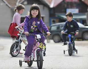 Image showing happy childrens group learning to drive bicycle