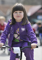 Image showing cute little girl driving bicyle at sunny day