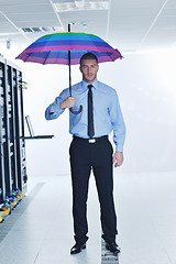 Image showing businessman hold umbrella in server room