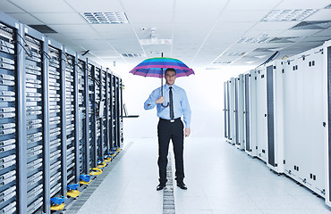 Image showing businessman hold umbrella in server room